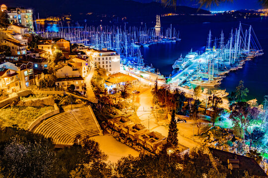 Fethiye, Turkey - February 19, 2025: view of moored yachts and Telmessos Amphitheatre at night