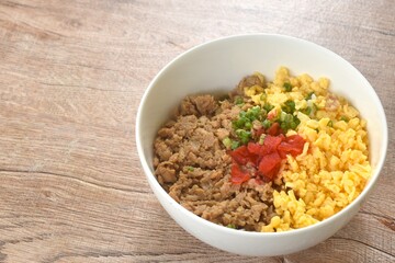 fried chop chicken and sweet egg toppiing red pickled cucumber on rice or tori soboro don japanese food in bowl