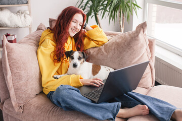 Relaxing young woman using laptop in living room