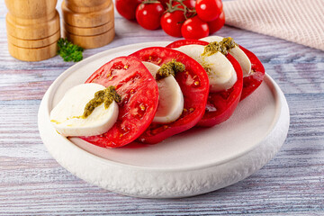 Italian Caprese salad with tomato, mozarella and pesto