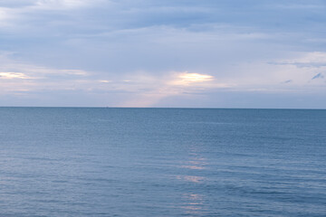 Calm waters reflect the sky during sunset at a tranquil beach on a peaceful evening