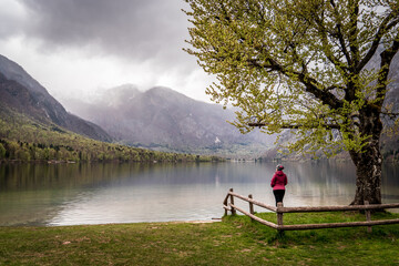 Mujer contemplando en soledad las vistas del lago Bohinj un día de otoño en Eslovenia