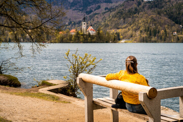 Mujer viajera sentada en un banco en la rivera del lago Bled, en Eslovenia © Javier