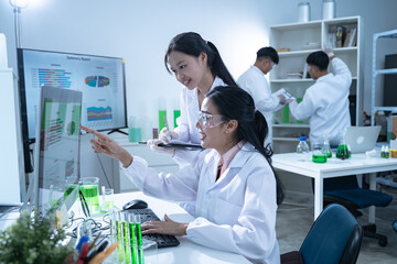 In the laboratory, a biologist uses advanced technology and computer analysis to compare data from experiments, conducting research to uncover new scientific insights in biology.