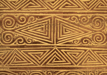 Complicated triangle patterns on an old wooden door create an interesting background in brown colors
