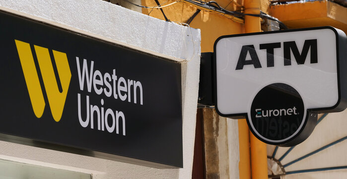 Portugal, Loul&eacute;, August 09. 2025, signage for a store offering Western Union services and a Euronet ATM