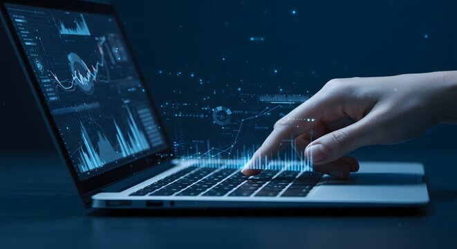 Close-up of a hand typing on a laptop with digital financial data and charts on screen, glowing particles