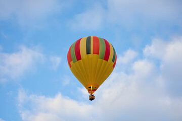 Fototapeta premium Colorful hot air balloon ascending against a blue sky
