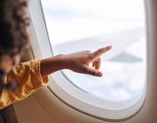 Obraz premium Child Pointing At Clouds Through Airplane Window
