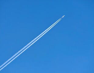 Airplane With Contrails In Bright Blue Sky