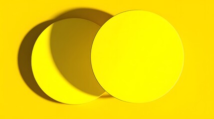 Two overlapping circular shapes of bright yellow against a bright yellow background.