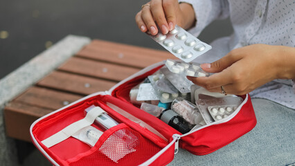 First aid kit. Park bench. Woman and first aid kit. High quality photo.