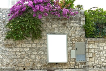 Portrait poster board on a stone wall.