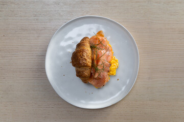 Croissant with smoked salmon and scrambled eggs.