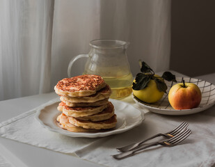 Breakfast served on the table - pancakes, green tea, apples