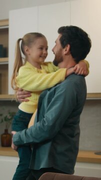 Happy affectionate Caucasian family in kitchen home father man dad with kid daughter cuddling hugging holding child girl talking carefree devotion parenting good fatherhood bonding insurance concept