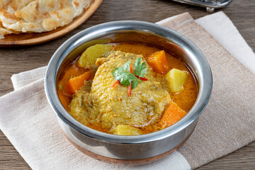 thai yellow chicken curry and roti in stainless steel bowl