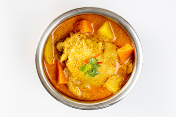 thai yellow chicken curry and roti in stainless steel bowl on a white background