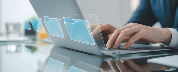 Digital Workplace: A close-up captures a professional hands focused on a laptop keyboard, navigating virtual file folders that materialize as a futuristic representation of the digital workplace