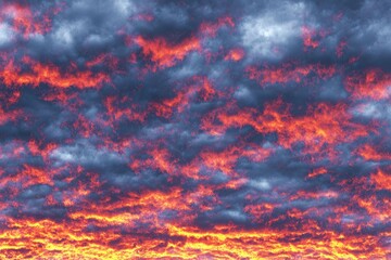 Fiery sunset clouds clashing with a stormy sky