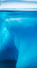 Underwater view of a glacial iceberg, showcasing vibrant blue hues and icy texture, symbolizing the Arctic's beauty and fragility, ideal for nature or environmental themes