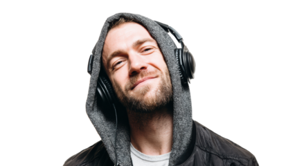 Young man smiling while wearing headphones and a hoodie, expressing enjoyment of music.