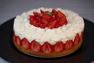 This fraisier cake showcases layers of fresh strawberries and chantilly cream on a golden sponge base, presented beautifully for dessert enthusiasts during a special gathering.