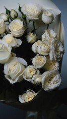 Beautiful white roses in a flower shop. Florist assembles a bouquet to order