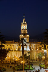 The sun sets over the Plaza de Armas in Arequipa, casting golden light on the majestic Basilica...