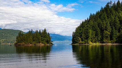 Fototapeta premium Harrison lake nearby areas within Sasquatch provincial park showing the rocky shoreline, forested backdrop, and glimpses of recreational spots, Harrison, BC, Canada