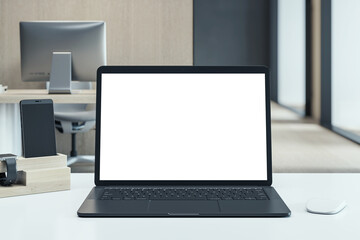 Fototapeta premium Modern black laptop with blank white screen on desk in clean office environment, showcasing workspace technology setup for mockup display template. 3D Rendering