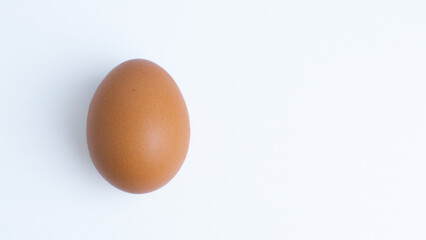 A single brown chicken egg with copy space on a white background. Concepts for food, ingredient, protein, healthy, breakfast, cooking, organic, fresh, isolated.
