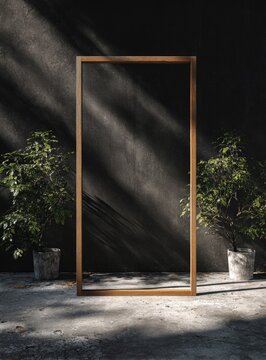 A tall, rustic wooden frame stands against a dark, textured wall, flanked by potted plants in dappled sunlight.  The concrete floor shows light and shadow