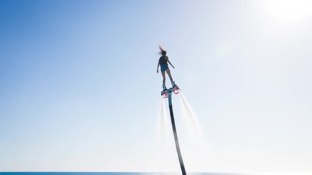 Woman enjoying flyboarding adventure on clear blue ocean