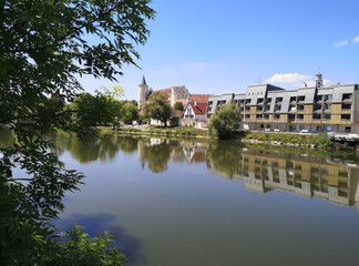 Fototapeta premium Lauingen an der Donau mit Donaustrand und Brücke bei Sonnenschein und blauem Himmel, Enten und Gänse füttern