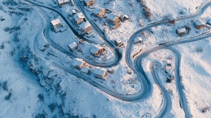 Distant alpine village in winter with snowy roads winding between small wooden homes