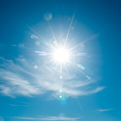 The radiant midday sun shines brilliantly in a clear blue sky, creating a beautiful starburst effect and lens flare over a soft cloud.
