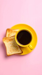 Overhead view of simple breakfast with coffee in yellow mug and toasted bread on pink background for minimal food and lifestyle concept.

