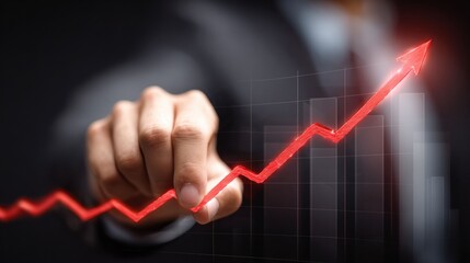 A hand, either holding or pointing to an illuminated performance bar graph, highlights business success and the ongoing process of tracking progress and achieving targets.