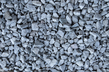 Gray small rocks ground texture. black small road stone background