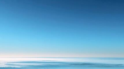 Obraz premium A serene view of the calm ocean under a bright blue sky, perfect for evoking peace and tranquility.