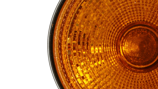 Closeup of amber reflector light lens with concentric pattern isolated on the transparent background