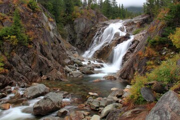 Fototapeta premium Waterfall cascading down rocky gorge in autumn