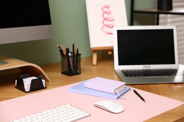 Stylish workplace with modern computer, laptop and stationery on wooden desk indoors
