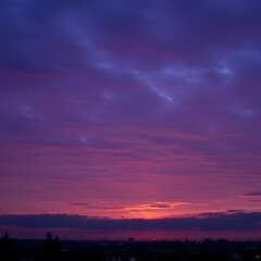 Fototapeta premium Serene cityscape silhouette under a magnificent and vibrant purple twilight sky with magenta clouds.