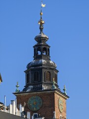 Obraz premium Clock Tower of St. Mary's Basilica in Krakow, Poland against a Clear Blue Sky