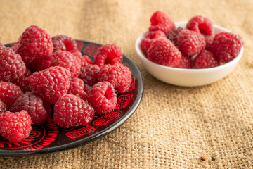 Sweet ripe raspberries on jute cloth, macro.