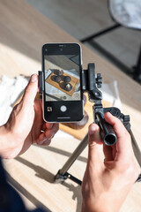 Man taking picture of chocolate muffins in studio, above view. Professional food photography