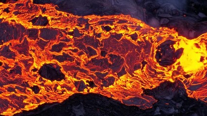 Molten Lava Flowing Vivid Orange and Red Over Dark Rocks Creates a Visually Striking Texture of Earth's Intense Power