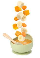 Baby food. Slices of pumpkin, banana and carrot falling into bowl of puree on white background